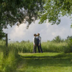A couple embraces on their wedding day in a field at Gedney Farm in the summer