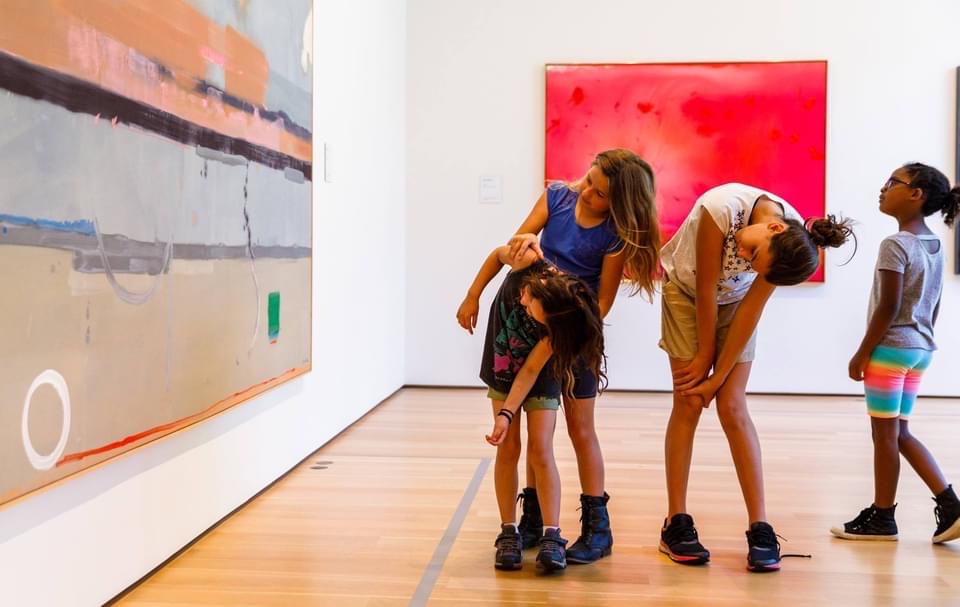 A group of children look at art at The Clark upside down, for a new angle.