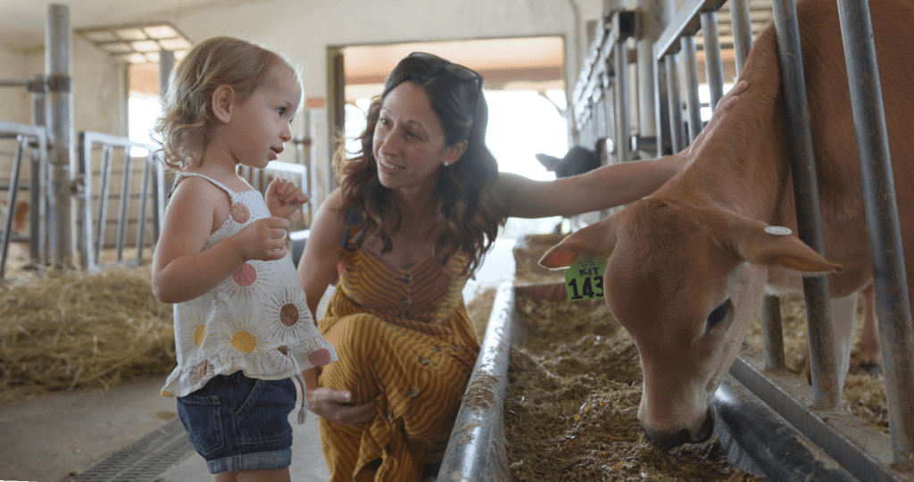 A woman and young child pet a calf