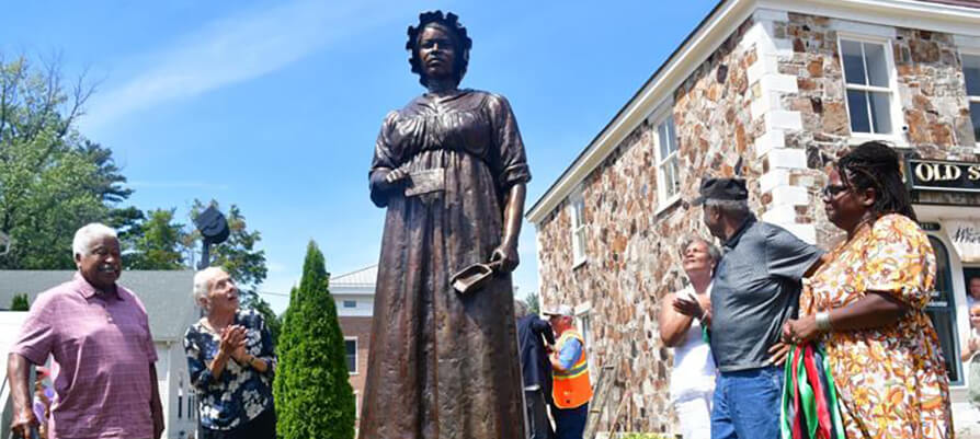 A statue of Elizabeth Freeman stands tall among onlookers.
