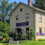 A wide shot of the Susan B. Anthony Birthplace Museum in spring on a sunny day