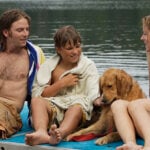 A family and dog sit on the dock, wet from swimming in the calm Onota Lake in Pittsfield.