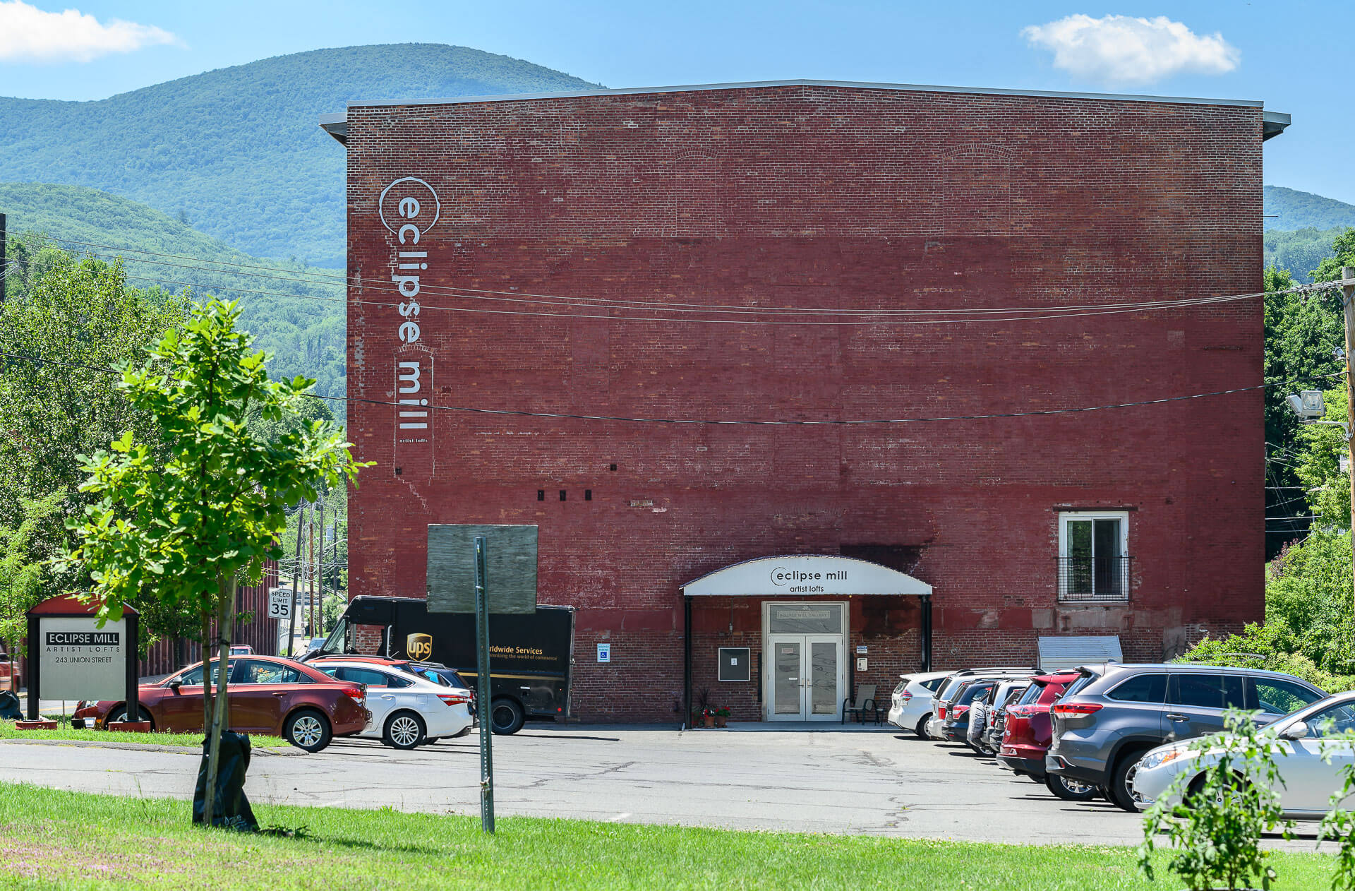 A picture of the red brick entrance wall of the Eclipse Mill, with the mountains in the background