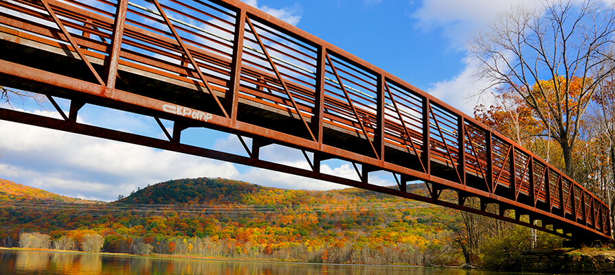 Bridge above water surrounded by colorful fall foliage scene