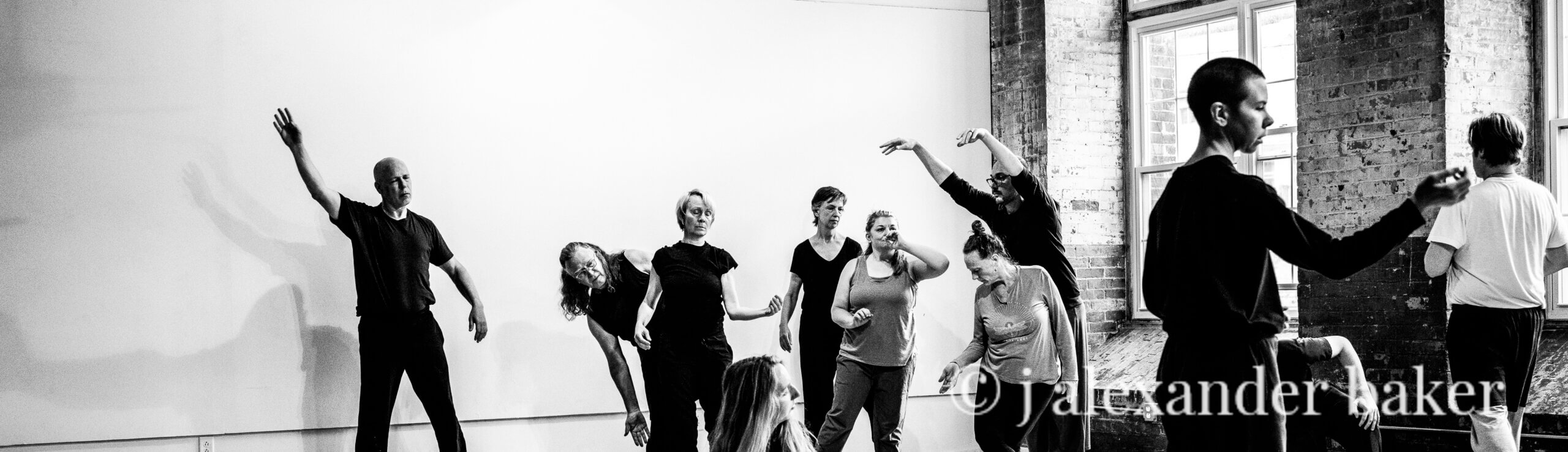A black and white image of people in various poses during an improvisational movement performance