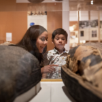 Curator teaches young boy about the mummy