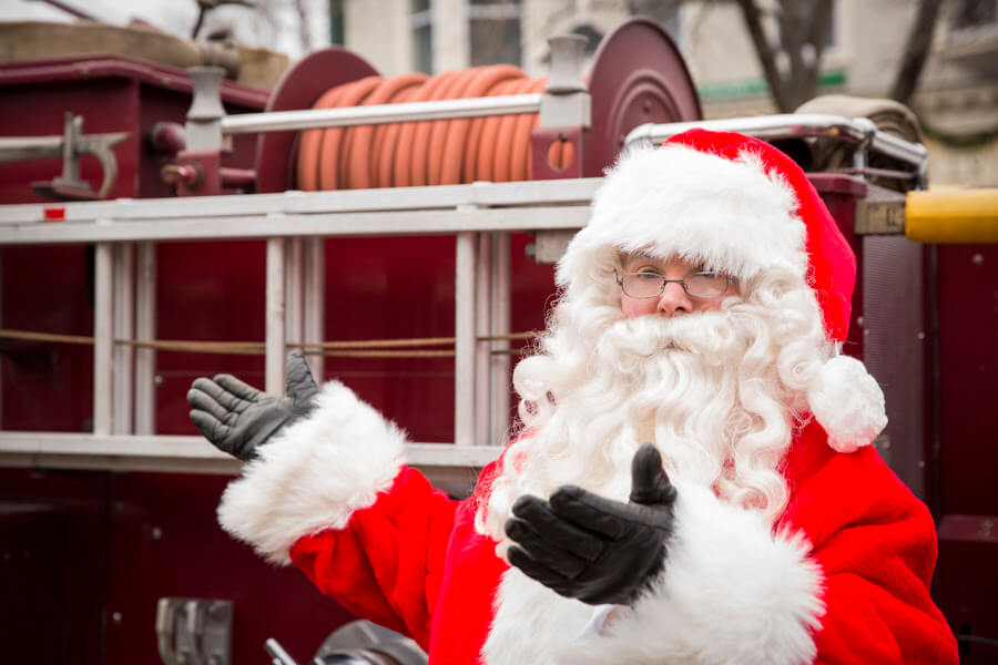 Santa standing next to a fire truck