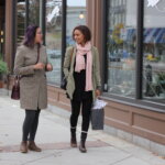 Friends walking along the shop lined sidewalk in Pittsfield