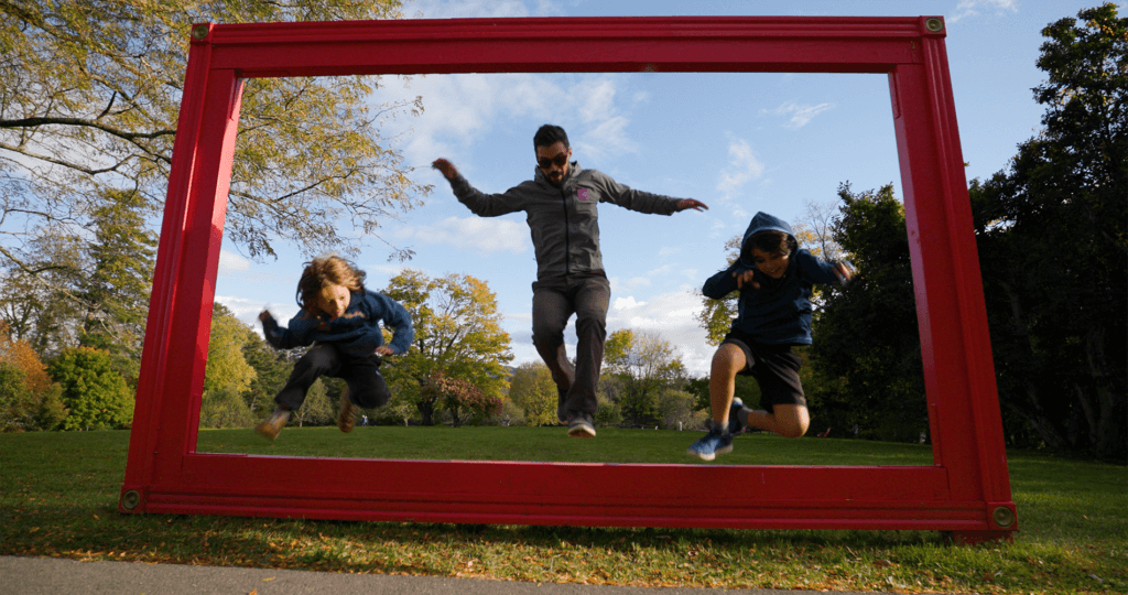 A father and children jumping through an art exhibit at Norman Rockwell Museum in the Berkshires.