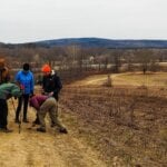 A group of hikers investigates animals tracks