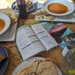 Table filled with sandwiches and soups for lunch, surrounding the Official Guide to the Berkshires book