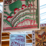 A colorful banner at the Yiddish Book Center hangs from the bright ceiling, surrounded by other banners