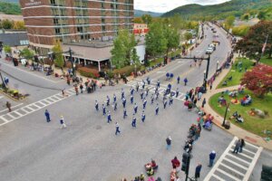 Aerial shot of a band marching over the bridge during the Fall Foliage Parade.