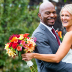 A bride and a groom stand embracing outside their wedding at Gedney Farm