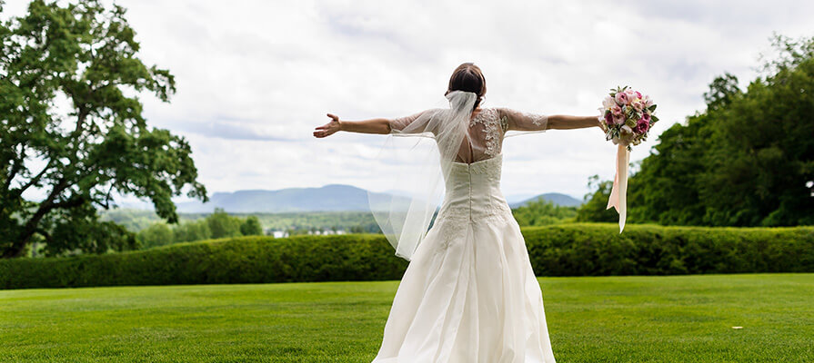 A bride stands open arms after a wedding at Tanglewood