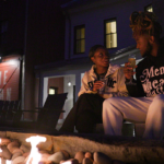 A couple sits fireside at the Williams Inn with glasses of wine