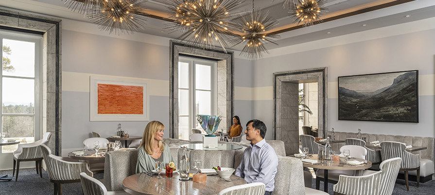 A couple sits in the luxurious bright dining room at Canyon Ranch