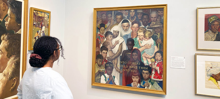 A woman looks at the Golden Rule artwork at the Norman Rockwell Museum