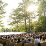 A large crowd watches a performance on the outdoor stage at Jacob's Pillow