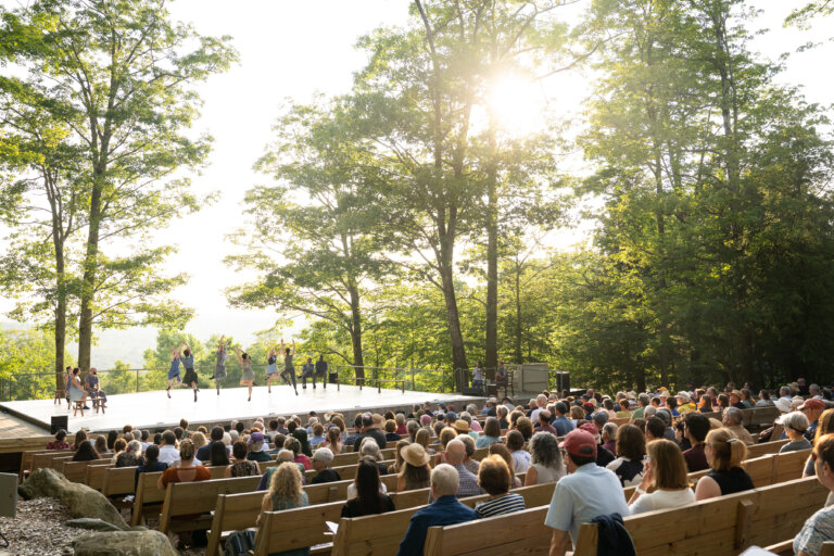 A large crowd watches a performance on the outdoor stage at Jacob's Pillow