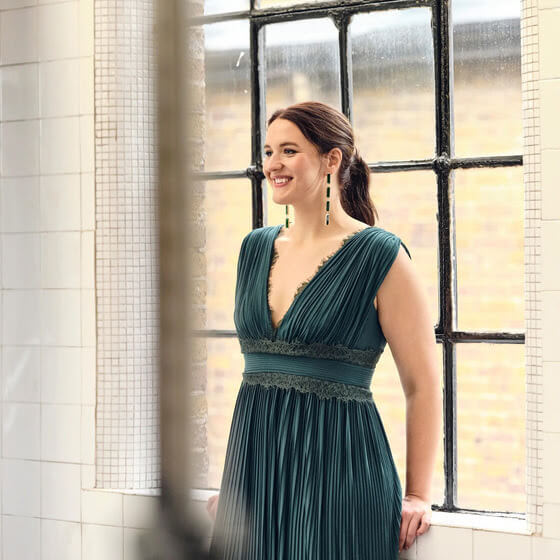 A smiling young woman performs in Fidelio