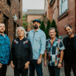 Band Members from Pure Prairie League pose in front of a brick building