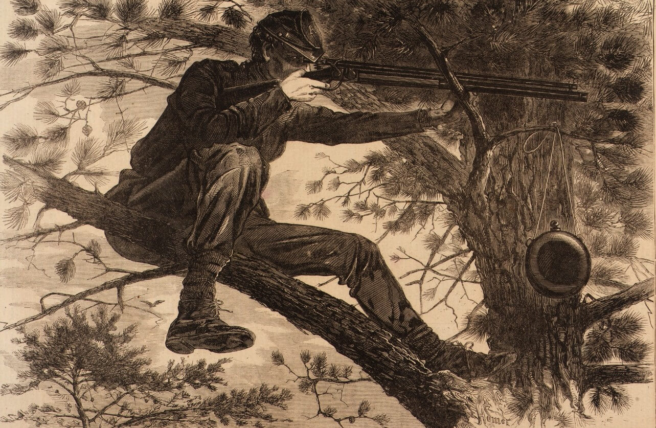 A soldier takes arm high up in a tree