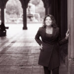 black and white image of Roseanne Cash under a curved portico