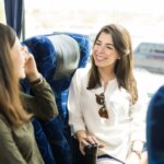 Two smiling women on board a bus headed for Canyon Ranch