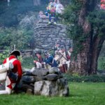 Actors in revolutionary costumes act out a scene from the Revolutionary War, highlighting the event of living history at the Bidwell House.