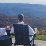 coffee and a view _Blue Vista Motor Lodge_lodging_ places to stay fall vista mountains (2) 895×400 a couple looks out over the foliage covered mountain at Blue Vista Motor Lodge