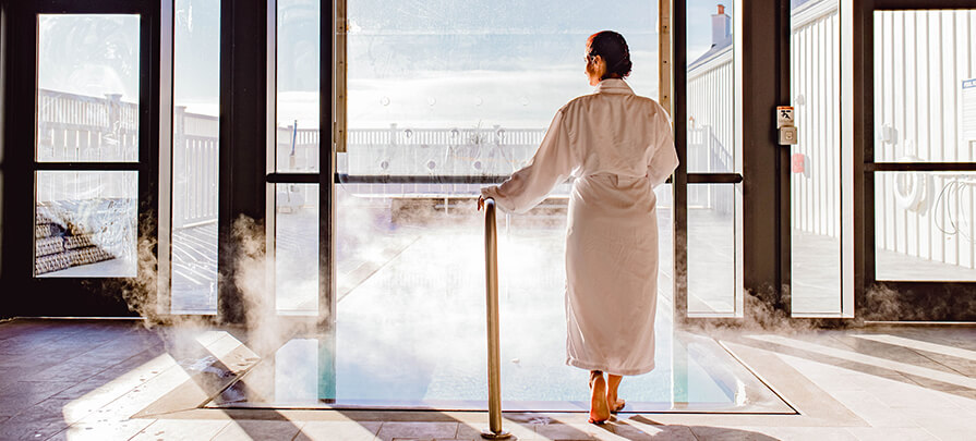 A woman in a robe enjoys the ambiance of the Miraval spa pool