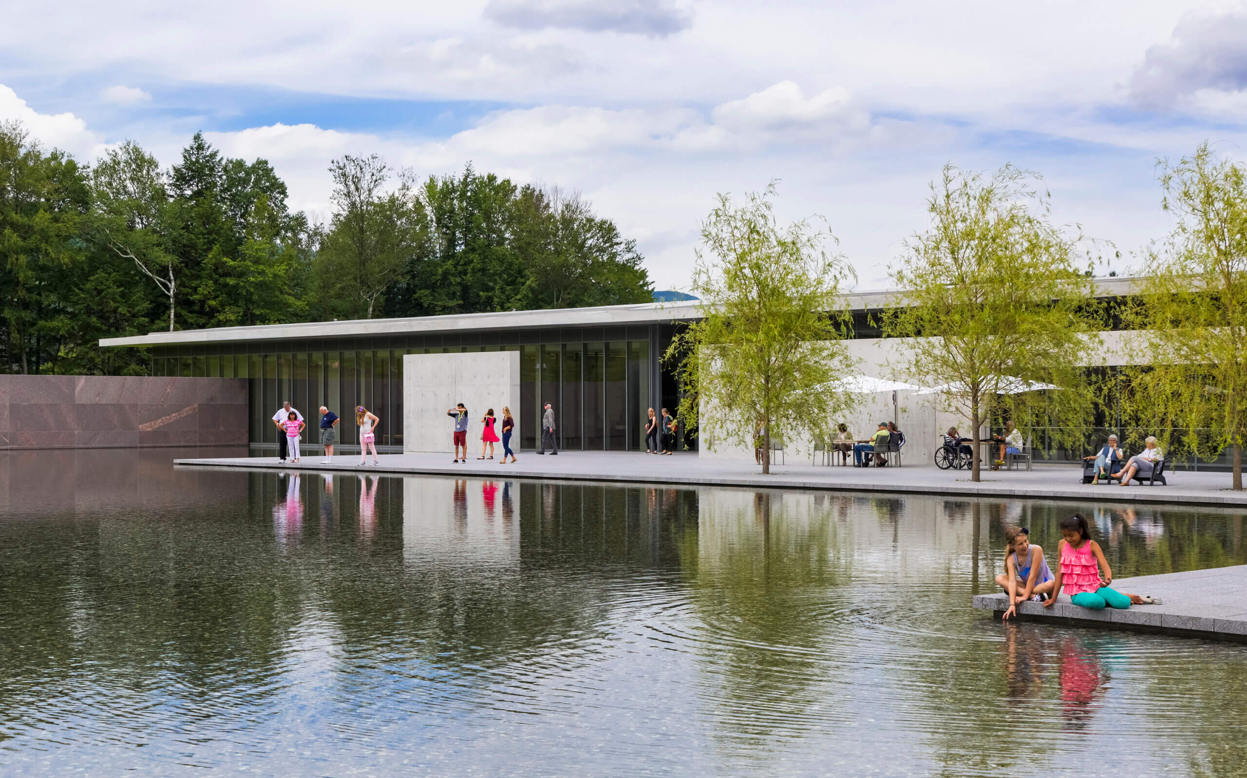 Groups of people gather around the reflection pool at The Clark in summer