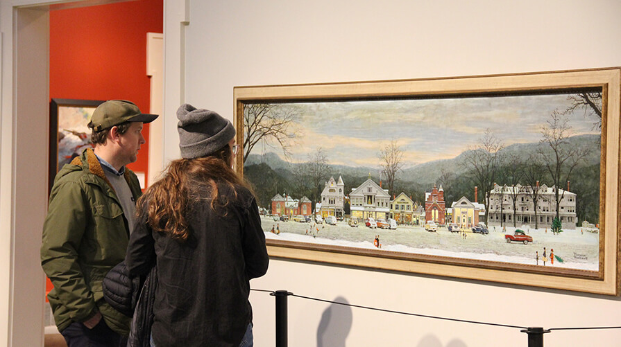 a couple stands in front of a painting at the Norman Rockwell Museum