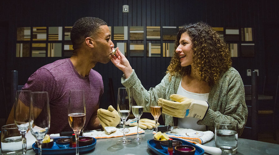A couple enjoys a meal of oysters and champagne 