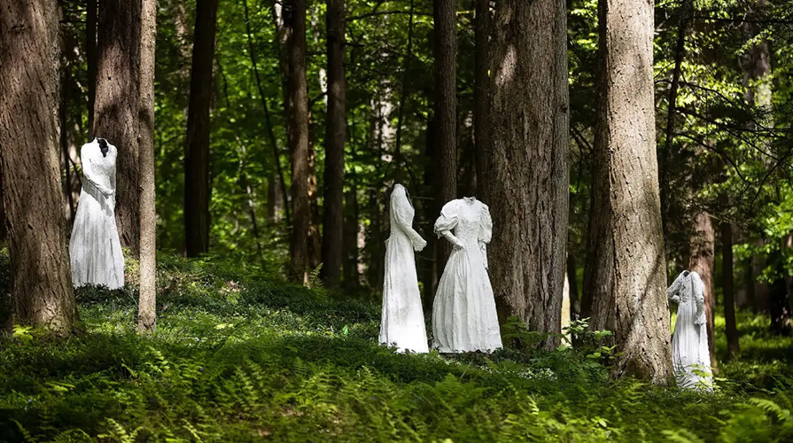 Outdoor sculptures stand in the woods at The Mount