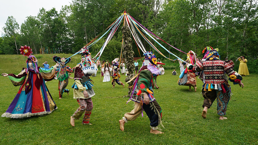 People in costume dance around the may pole at TurnPark Art Space