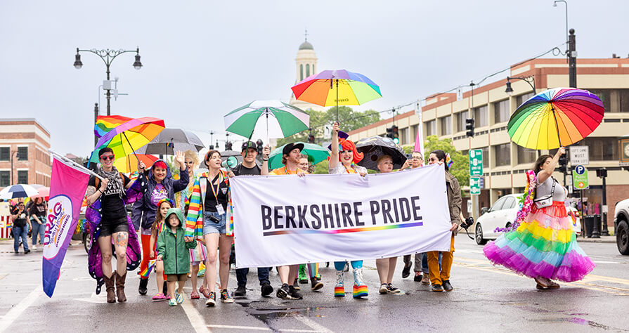 A group from Berkshire Pride hold a banner and march down North Street in Pittsfield wearing rainbow in support of Pride Month